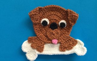 Finished crochet dog with a bone landscape