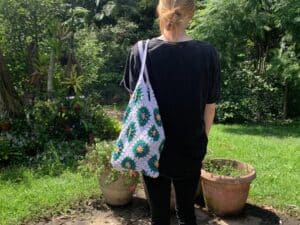 Finished crochet granny square shopping bag white with model landscape