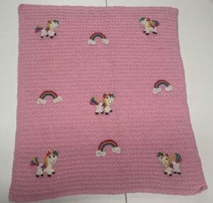 Crochet unicorn baby blanket laid out